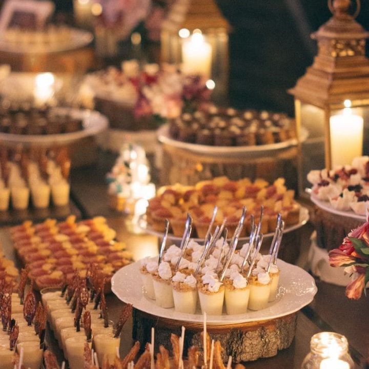 Mini postres en vasitos entre faroles y velas encendidas